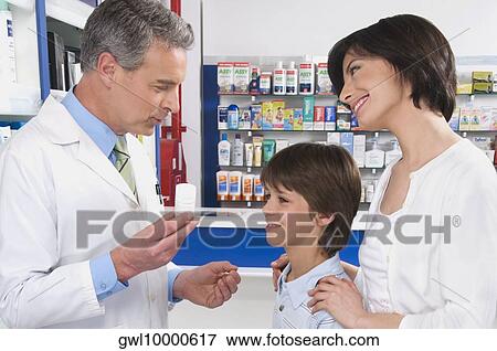 Pharmacist talking with a boy and his mother View Large Photo Image Stock Photo - Pharmacist talking with a boy and his mother. Fotosearch