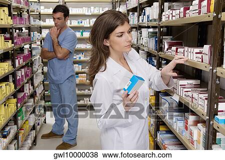 Pharmacists working in a pharmacy View Large Photo Image Stock Photo - Pharmacists working in a pharmacy. Fotosearch