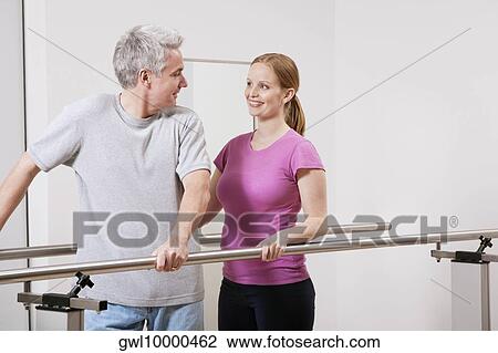Physiotherapist assisting a patient in walking View Large Photo Image Stock Image - Physiotherapist assisting a patient in walking. Fotosearch