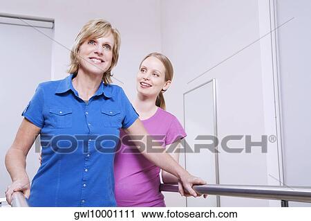 Physiotherapist assisting a patient in walking View Large Photo Image Stock Image - Physiotherapist assisting a patient in walking. Fotosearch