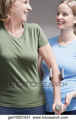 Physiotherapist assisting a patient in walking with crutches View Large Photo Image Stock Image - Physiotherapist assisting a patient in walking with crutches. Fotosearch