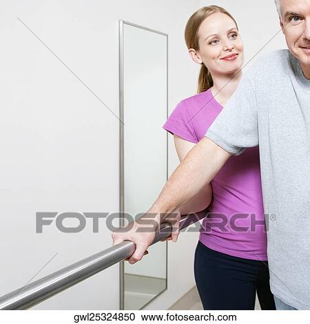 Physiotherapist assisting a patient in walking View Large Photo Image Stock Image - Physiotherapist assisting a patient in walking. Fotosearch