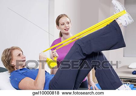 Physiotherapist assisting a patient in exercising View Large Photo Image Stock Photo - Physiotherapist assisting a patient in exercising. Fotosearch