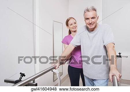 Physiotherapist assisting a patient in walking View Large Photo Image Stock Photo - Physiotherapist assisting a patient in walking. Fotosearch