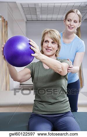 Physiotherapist assisting a patient in exercising View Large Photo Image Stock Photo - Physiotherapist assisting a patient in exercising. Fotosearch