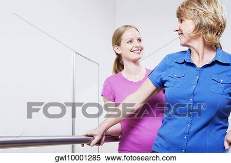 Stock Photography - Physiotherapist assisting a patient in walking. Fotosearch