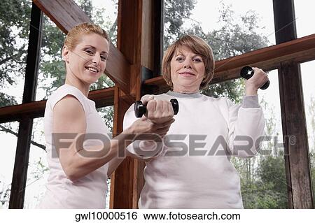 Physiotherapist helping a disabled woman in exercising View Large Photo Image Stock Photograph - Physiotherapist helping a disabled woman in exercising. Fotosearch