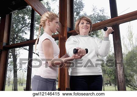 Physiotherapist helping a disabled woman in exercising View Large Photo Image Stock Photography - Physiotherapist helping a disabled woman in exercising. Fotosearch