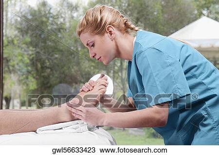 Physiotherapist massaging a person's foot View Large Photo Image Stock Image - Physiotherapist massaging a person's foot. Fotosearch