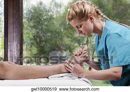 Stock Photo - Physiotherapist massaging a person's foot. Fotosearch