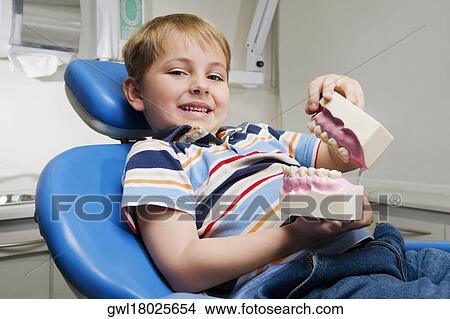 Portrait of a boy holding a set of dentures View Large Photo Image Picture - Portrait of a boy holding a set of dentures. Fotosearch