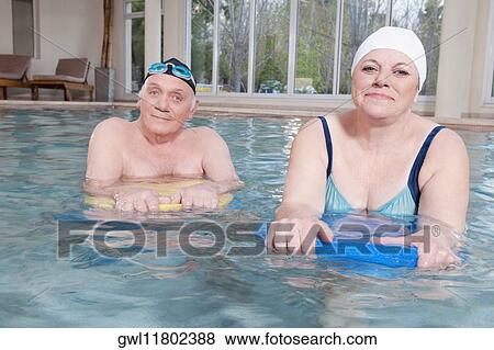 Portrait of a couple swimming with floats in a swimming pool View Large Photo Image Stock Photo - Portrait of a couple swimming with floats in a swimming pool. Fotosearch
