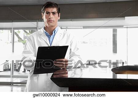 Portrait of a doctor holding a clipboard View Large Photo Image Picture - Portrait of a doctor holding a clipboard. Fotosearch