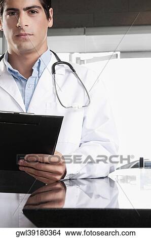 Portrait of a doctor holding a clipboard View Large Photo Image Picture - Portrait of a doctor holding a clipboard. Fotosearch