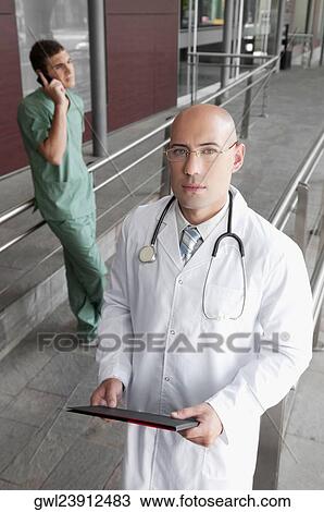 Portrait of a doctor holding a medical report View Large Photo Image Stock Image - Portrait of a doctor holding a medical report. Fotosearch