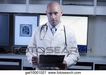 Portrait of a doctor holding a medical report View Large Photo Image Stock Photo - Portrait of a doctor holding a medical report. Fotosearch