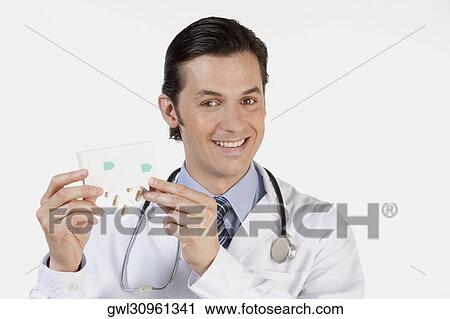Portrait of a doctor holding a pack of medicine View Large Photo Image Stock Image - Portrait of a doctor holding a pack of medicine. Fotosearch
