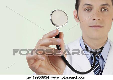 Portrait of a doctor holding a stethoscope View Large Photo Image Picture - Portrait of a doctor holding a stethoscope. Fotosearch