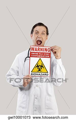 Portrait of a doctor showing a Biohazard warning sign View Large Photo Image Stock Image - Portrait of a doctor showing a Biohazard warning sign. Fotosearch