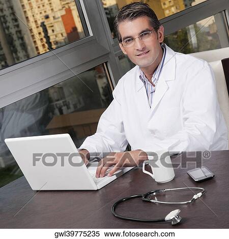 Portrait of a doctor working on a laptop View Large Photo Image Stock Photography - Portrait of a doctor working on a laptop. Fotosearch