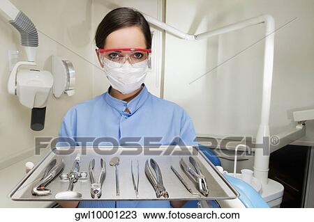 Portrait of a female dentist holding a tray of dental equipments View Large Photo Image Stock Image - Portrait of a female dentist holding a tray of dental equipments. Fotosearch