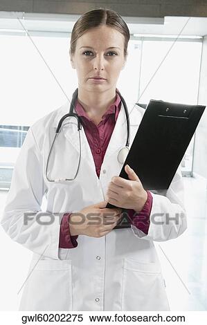 Portrait of a female doctor holding a clipboard View Large Photo Image Stock Photography - Portrait of a female doctor holding a clipboard. Fotosearch