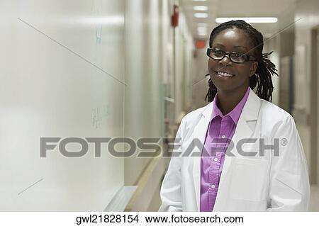 Portrait of a female doctor smiling in a hospital corridor View Large Photo Image Picture - Portrait of a female doctor smiling in a hospital corridor. Fotosearch