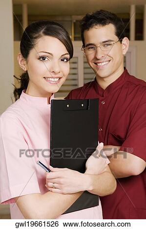 Portrait of a female doctor smiling with a male doctor View Large Photo Image Stock Photograph - Portrait of a female doctor smiling with a male doctor. Fotosearch