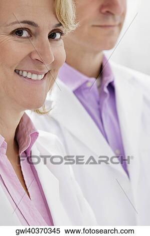 Portrait of a female doctor smiling with a male doctor View Large Photo Image Stock Photography - Portrait of a female doctor smiling with a male doctor. Fotosearch