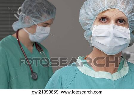 Portrait of a female doctor with a male doctor in the background View Large Photo Image Stock Photo - Portrait of a female doctor with a male doctor in the background. Fotosearch