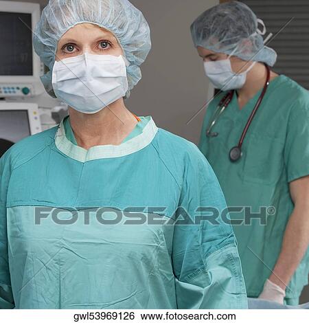 Portrait of a female doctor with her colleague standing behind her View Large Photo Image Stock Photograph - Portrait of a female doctor with her colleague standing behind her. Fotosearch