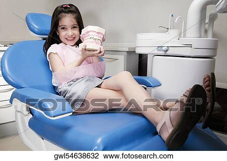 Portrait of a girl holding a set of dentures View Large Photo Image Stock Image - Portrait of a girl holding a set of dentures. Fotosearch