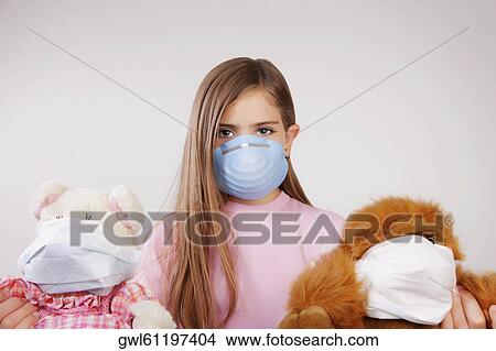 Portrait of a girl wearing a flu mask and holding stuffed toys View Large Photo Image Picture - Portrait of a girl wearing a flu mask and holding stuffed toys. Fotosearch