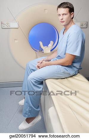 Portrait of a healthcare worker sitting on a CAT scan machine View Large Photo Image Picture - Portrait of a healthcare worker sitting on a CAT scan machine. Fotosearch