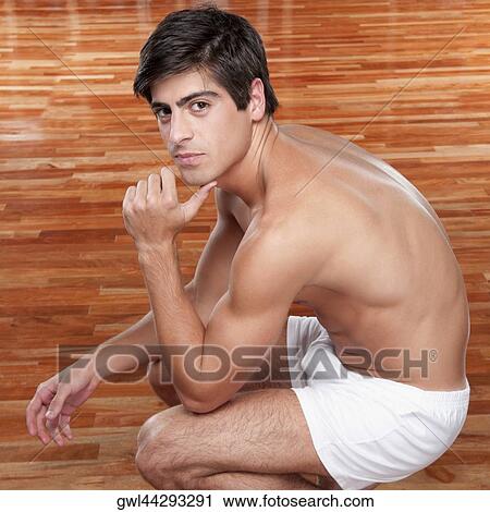 Stock Image - Portrait of a man crouching. Fotosearch