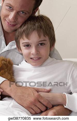 Portrait of a man hugging his son on a hospital bed View Large Photo Image Stock Photography - Portrait of a man hugging his son on a hospital bed. Fotosearch