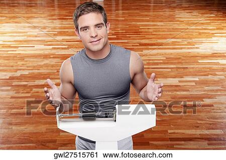 Portrait of a man measuring his weight on a weighing scale View Large Photo Image Stock Image - Portrait of a man measuring his weight on a weighing scale. Fotosearch