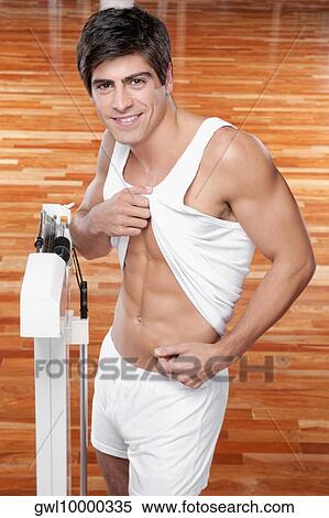 Portrait of a man pinching his waist and smiling View Large Photo Image Stock Photography - Portrait of a man pinching his waist and smiling. Fotosearch