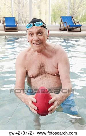 Portrait of a man playing with a rugby ball in a swimming pool View Large Photo Image Stock Photo - Portrait of a man playing with a rugby ball in a swimming pool. Fotosearch