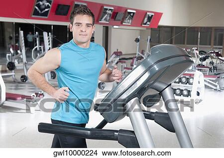 Picture - Portrait of a man running on a treadmill. Fotosearch