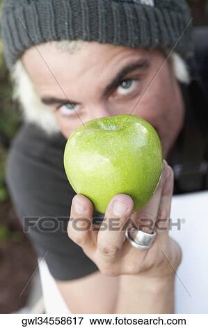 Portrait of a man showing a granny smith apple View Large Photo Image Stock Photo - Portrait of a man showing a granny smith apple. Fotosearch