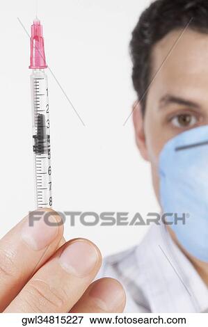 Portrait of a man showing a syringe View Large Photo Image Stock Photo - Portrait of a man showing a syringe. Fotosearch