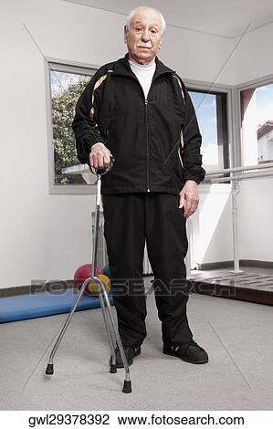 Portrait of a man standing with a crutch View Large Photo Image Stock Image - Portrait of a man standing with a crutch. Fotosearch