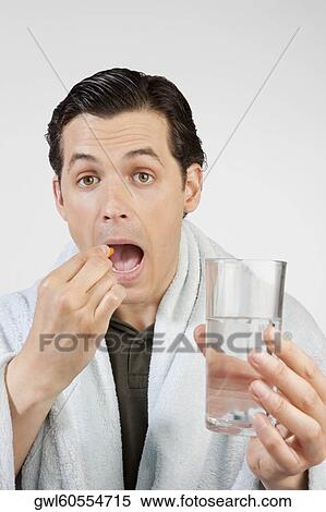 Stock Photography - Portrait of a man taking medicine. Fotosearch