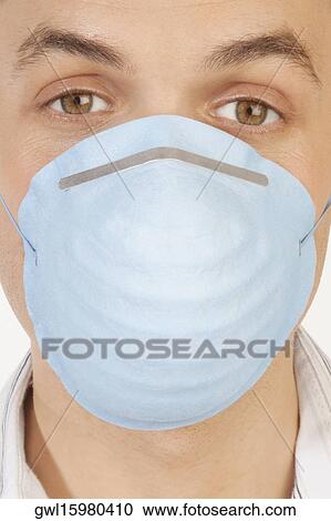 Stock Image - Portrait of a man wearing a flu mask. Fotosearch