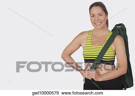Portrait of a woman carrying a bag and smiling View Large Photo Image Stock Photo - Portrait of a woman carrying a bag and smiling. Fotosearch