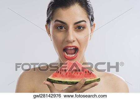Stock Photograph - Portrait of a woman eating a slice of watermelon. Fotosearch