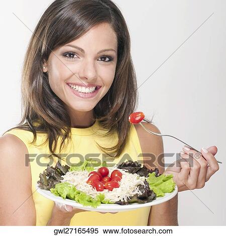 Stock Photography - Portrait of a woman eating salad. Fotosearch