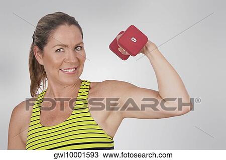 Portrait of a woman exercising with a dumbbell View Large Photo Image Stock Image - Portrait of a woman exercising with a dumbbell. Fotosearch