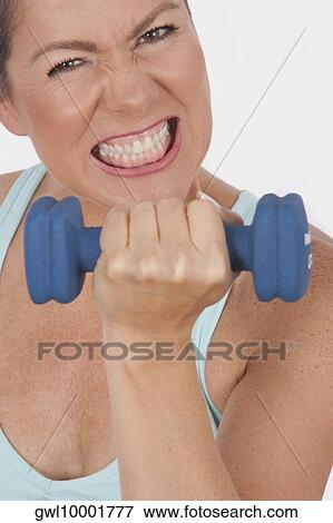 Portrait of a woman exercising with a dumbbell View Large Photo Image Stock Photo - Portrait of a woman exercising with a dumbbell. Fotosearch